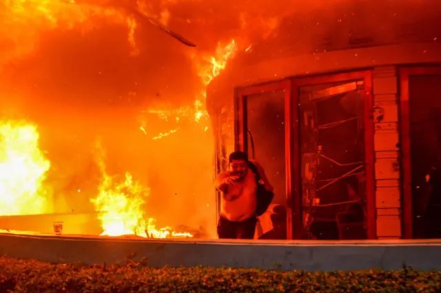 Seorang pegawai Mess MPR RI berlari keluar ruangan yang terbakar di Bandung, Jawa Barat, Jumat (29/8/2025).