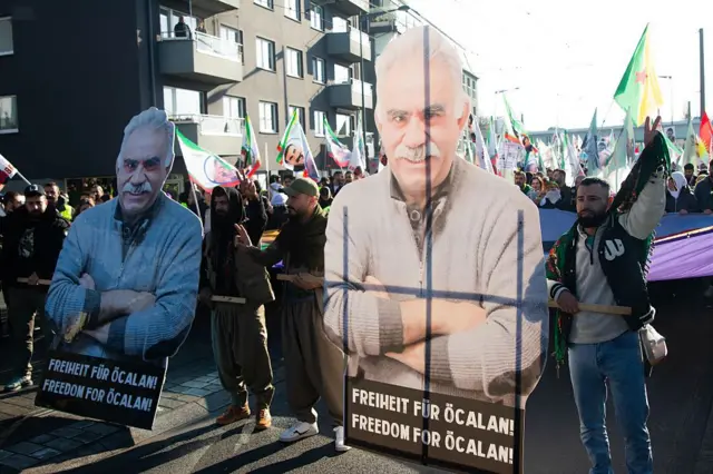 Almanya'nın Köln kentindeki eylemde Öcalan posterleri taşıyanlar. Posterlerde Öcalan'a özgürlük yazıyor.