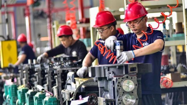 4月16日，在中国山东省青州市一家机械装备制造企业的车间里，工人们正在组装发动机。