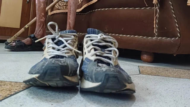 Sepatu lari berwarna biru dan putih terlihat sudah lusuh.