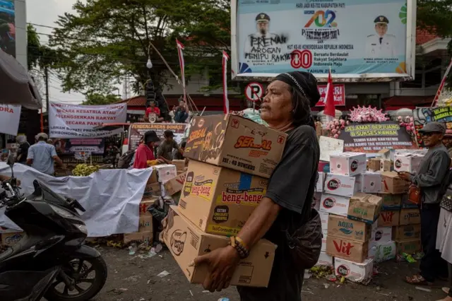Seorang warga membawa makanan ringan untuk didonasikan ke posko penggalangan donasi logistik unjuk rasa di depan Kantor Bupati Pati, Kabupaten Pati, Jawa Tengah, Selasa (12/8/2025).