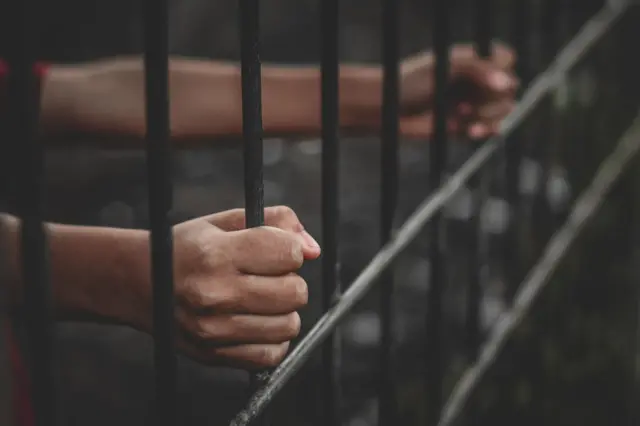 Demir parmaklıkları tutan iki el