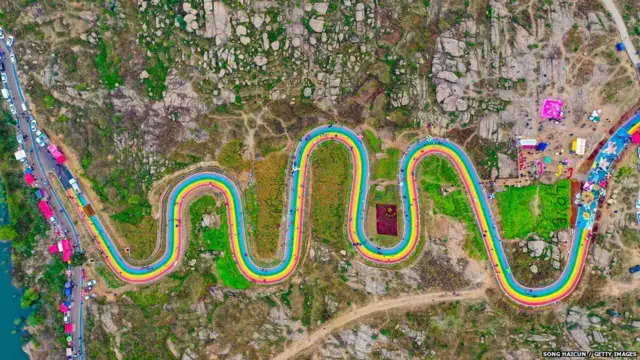 चीन के ज़ाओज़ुआंग प्रांतत की रंग बिरंगी सड़कों से गुज़रते लोग