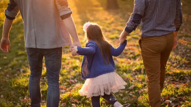 Uma criança andando com um casal gay ebonus de aposta bet speedmãos dadas