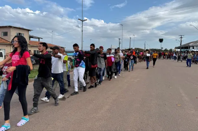 Refugiados venezuelanos fazem fila após cruzarem a fronteira entre a Venezuela e o Brasil na cidade de Pacaraima, Roraima
