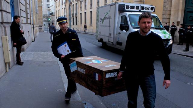 Des militants de l'association Survie déposent une caisse vide devant un bâtiment du ministère de la Défense à Paris.