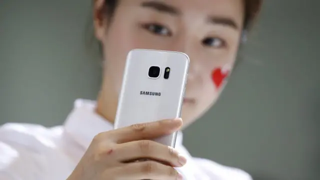 дівчина тримає в руках смартфон