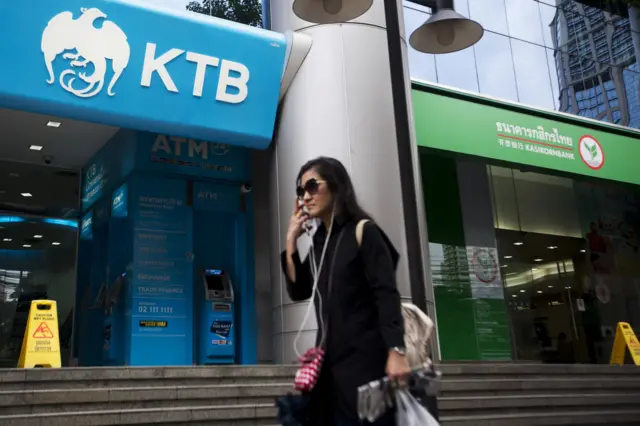 ผู้หญิงเดินผ่านธนาคาร