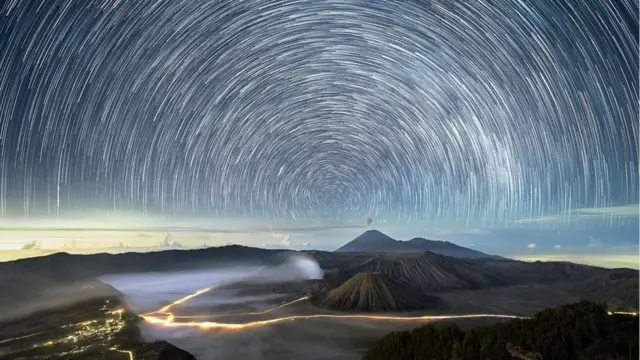 这幅在印度尼西亚拍摄的延时合成照片扭曲了人眼能看到的景象，构成了一幅夜空的抽象画卷（图片来源: Grey Chow）