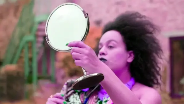 Quilla Constance looking into a mirror