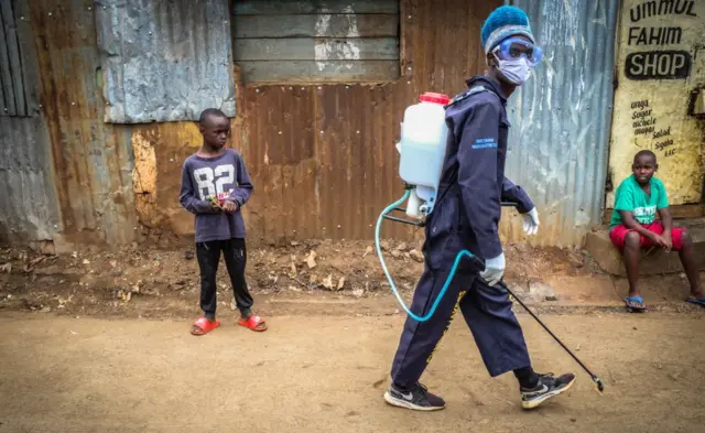 Un homme en EPI chargé de la désinfection dans un bidonville