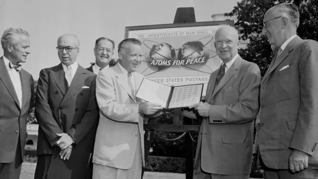 Homens sorrindo ao ladocomo funciona futebol virtual bet365cartaz com dizeres 'Atoms for Peace'