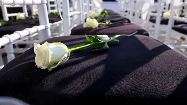 Bela ruža na tamnom sedištu bele stolice 