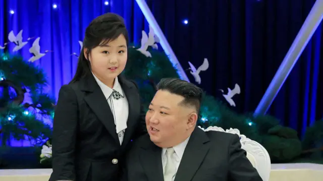 Ким Чжу Э алгачкы жолу эл алдына 2022-жылы чыккан. Бул сүрөт ал атасы менен 2023-жылдын февралында Корей эл армиясынын 75 жылдыгына арналган банкетке келгенде тартылган