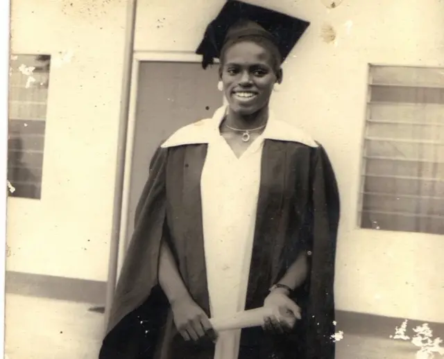 Ijeoma sonriendo vestida de graduada