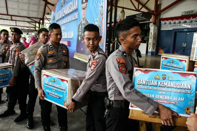 Sejumlah polisi mengangkut bantuan untuk korban bencana di Aceh pada 2 Desember 2025.