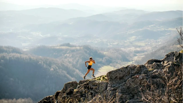 امرأة تركض على جبل صخري