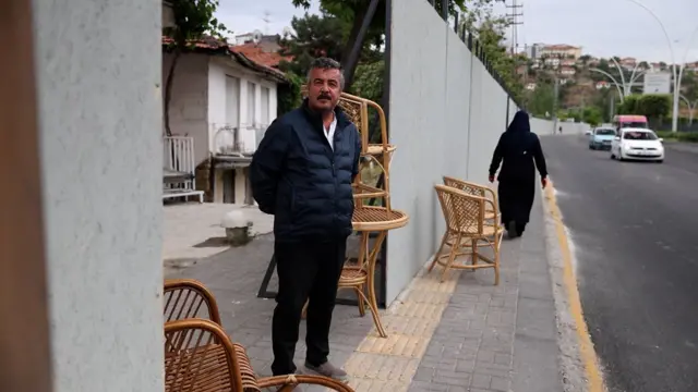 Esnaf Ümit Bodur dükkanının önündeki bariyerlerin arkasında kalan dükkanının durumundan şikayetçi. 