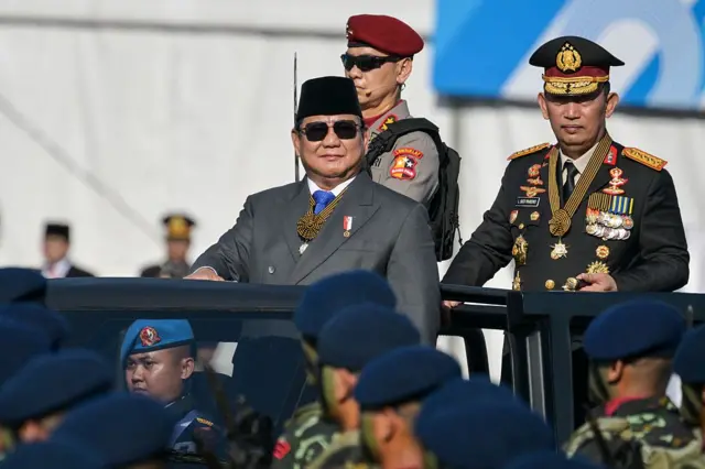 Presiden Prabowo Subianto (kiri) dan Kapolri Jenderal Listyo Sigit Prabowo (kanan) memeriksa pasukan kepolisian selama perayaan ulang tahun ke-79 Kepolisian Nasional Indonesia yang diadakan di Monumen Nasional (Monas) di Jakarta pada 1 Juli 2025. 