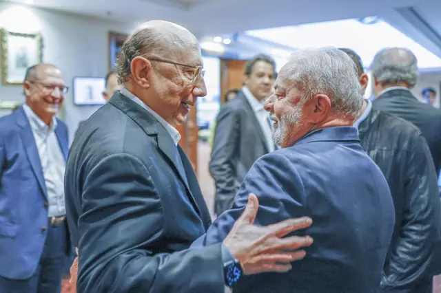 Meirelles e Lula se cumprimentam de forma calorosa