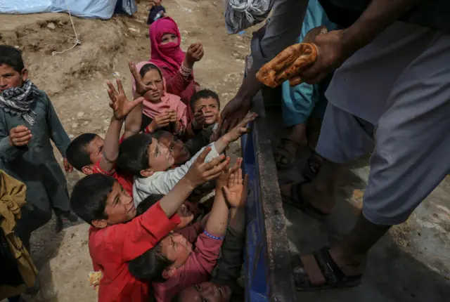 2024 మే 12న అఫ్గానిస్తాన్లోని బగ్లాన్లో ఒక గ్రామంలో వరద ప్రభావిత ప్రాంత ప్రజలకు ఆహారం అందిస్తున్న వాలంటీర్లు