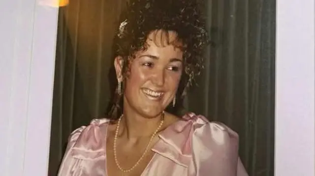 Керол на старому сімейному фото в рожевій атласній сукні, на ній перлове намисто 