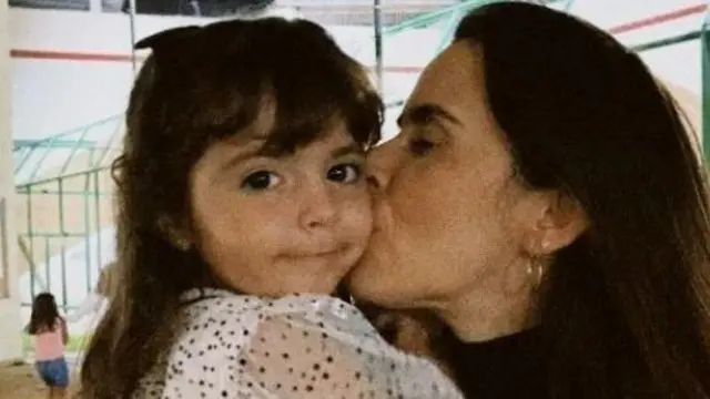 Kyara (à esquerda),melhores casas de cassino online3 anos, recebe um beijo da mãe Kayra (à direita)