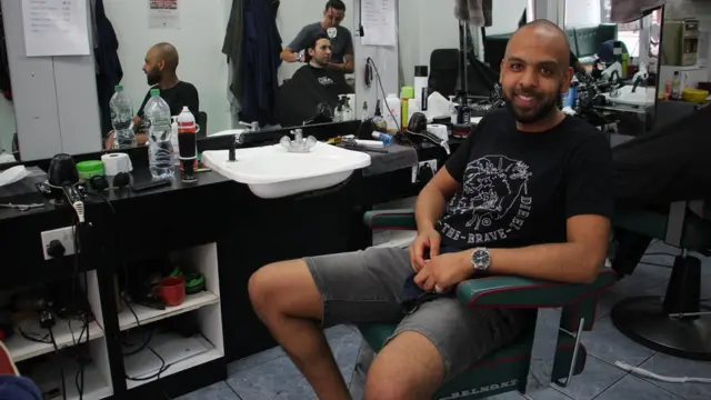 Oussama, 29 ans, est arrivé au Royaume-Uni en 2014. Originaire de Blida, à 50 km au sud-ouest d'Alger, il avait suivi des études d'interprétariat dans son pays natal. Aujourd'hui, il est coiffeur pour hommes à Londres : ''Si j'avais aimé [ma vie en Algérie], je ne serais pas ici.'' Le jour J, il espère une projection du match à l'extérieur afin de vivre la finale avec toute la communauté algérienne : '' Je n'aime pas le football mais je suis très très nationaliste.''