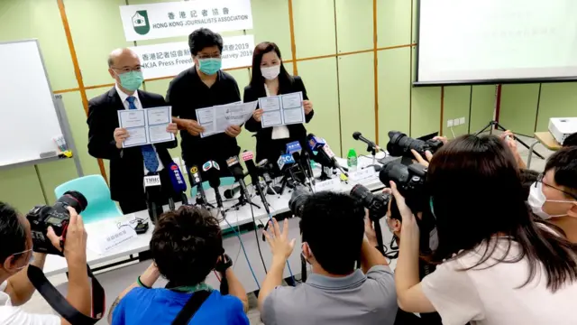 香港记协主席杨健兴（中）、香港中文大学新闻与传播学院教授苏钥机（左）与香港民研社会研究服务总监彭嘉丽（右）展示香港记协“2019年新闻自由指数调查”简报文件（11/5/2020）