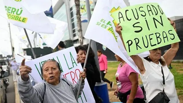 Mulheres na rua com cartazes, um deles dizendo: 'Acusado sin pruebas'