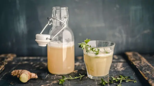 elma sirkesi şişesi ve elma sirkesi dökülmüş bir bardak