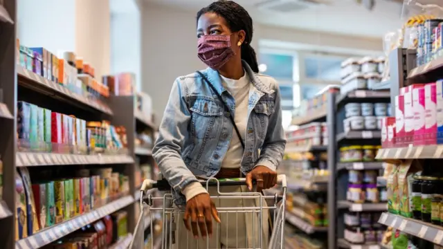 Mulher empurra seu carrinhojogo 2 jogadorescorredor do supermercado