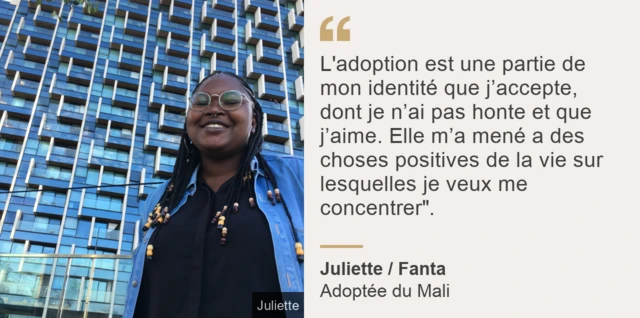 Fanta, souriante, devant un grant immeuble