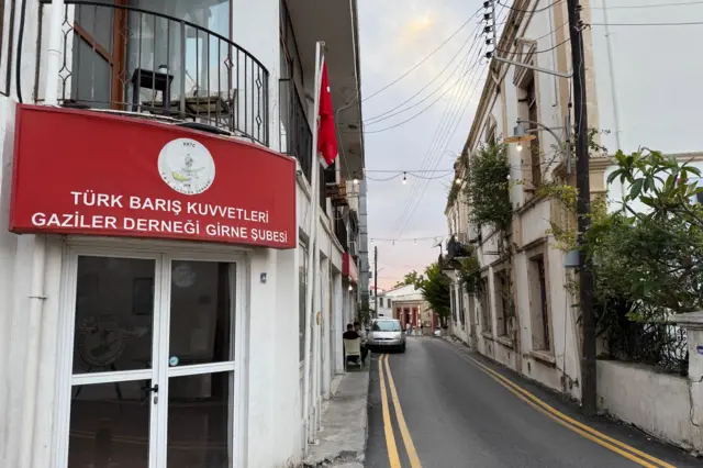 Kıbrıs'ın kuzeyinde 'Türk Barış Kuvvetleri Gaziler Derneği Girne Şubesi' tabelalı bir bina ve sokak