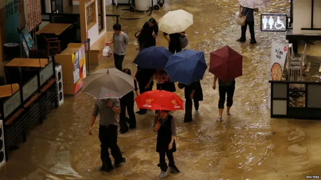 People wade through seawater inside a mall in Heng Fa Chuen, a residental district near the waterfront in Hong Kong, China September 16, 2018.