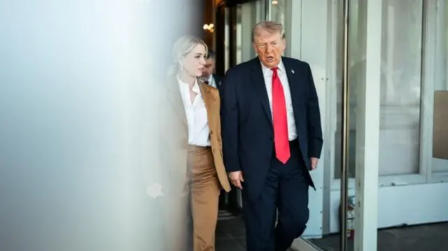 Trump e Bondi caminhando lado a lado na Suprema Corte dos EUA em 1º de abril de 2026. Ela veste terno feminino bege e camisa branca e ele usa um terno azul marinho com gravata vermelha e camisa branca