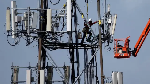Un trabajador en una torre de red celular