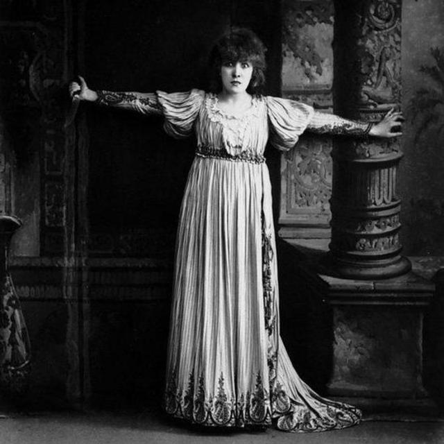 Sarah Bernhardt como Floria de braços abertos e vestido