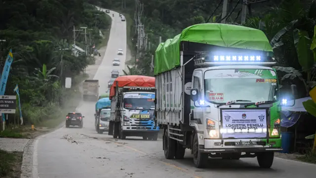 Sejumlah truk yang membawa logistik Pemilu 2024 melintasi kawasan Ibu Kota Nusantara (IKN) di Sepaku, Kabupaten Penajam Paser Utara, Kalimantan Timur, Minggu (11/2/2024). Sebanyak 580 kotak suara akan didistribusikan ke 116 Tempat Pemungutan Suara (TPS) di Desa Bumi Harapan, Kecamatan Sepaku, yang masuk dalam wilayah calon ibu kota negara baru Indonesia.