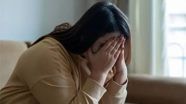 امرأة تغطي وجهها بكفيها