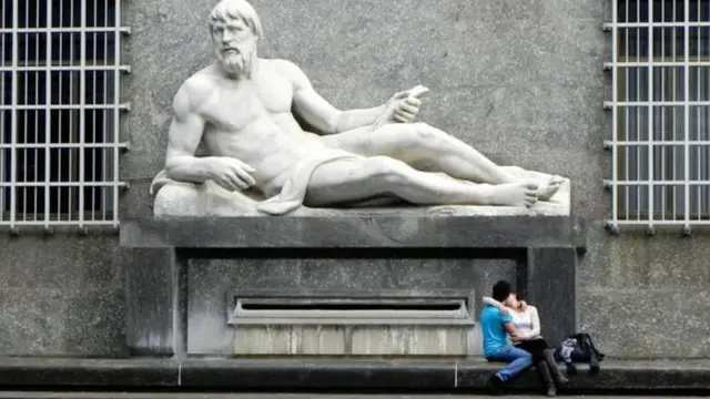 عاشقان تحت تمثال في مدينة تورينو الإيطالية