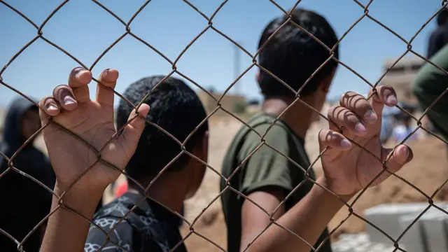 Dos niños se agarran a una valla en Cisjordania