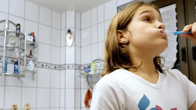 Дівчина чистить зуби