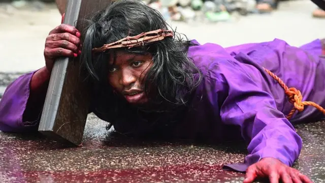 Man for ground wey carry cruxifix.