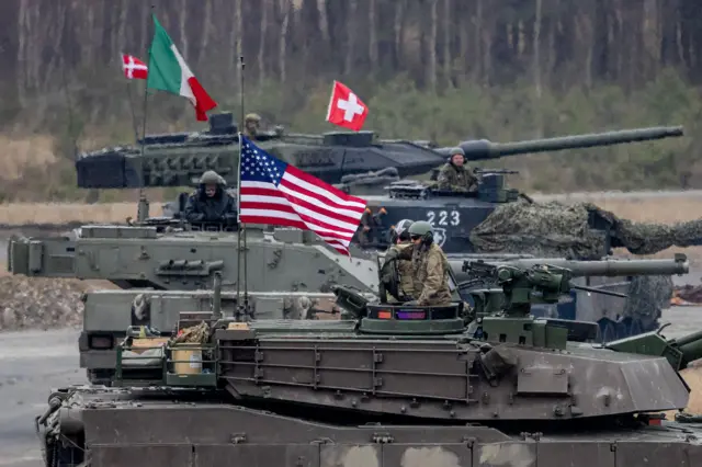 Датский танк Leopard 2 (сзади), швейцарский танк Leopard 2 (второй сверху), итальянский танк Ariete (второй спереди) и американский танк M1A2 SEP V2 (спереди) принимают участие в учениях “US Army Europe and Africa International Tank Challenge” на военном полигоне в Графенвёре, Германия, 11 февраля 2025 г.
