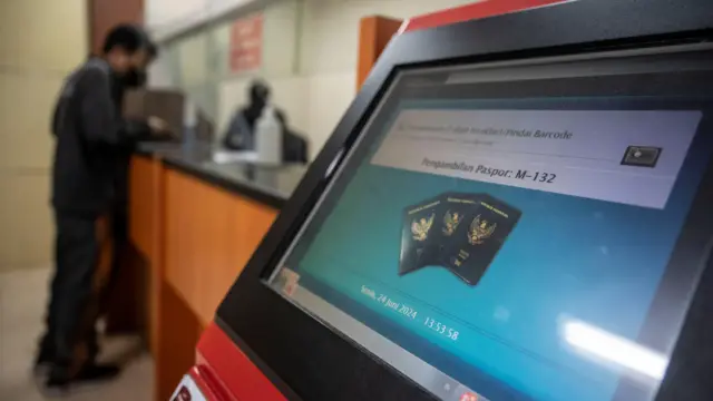 Seorang pemohon paspor mengambil paspornya di Kantor Imigrasi Kelas 1 Khusus Non TPI Jakarta Barat, Jakarta, Senin (24/6)