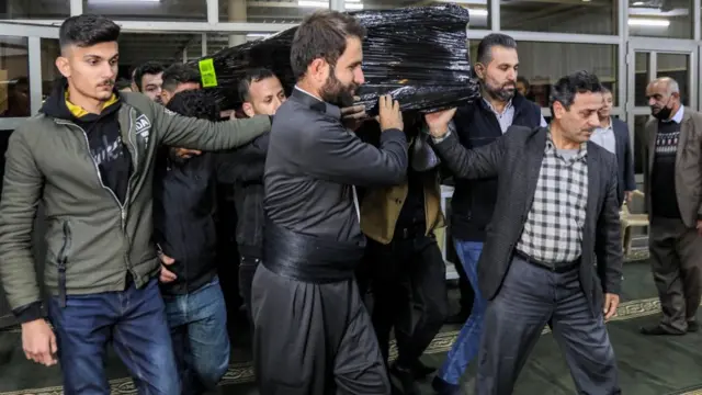 رجال أكراد يحملون نعش مهاجر لقي حتفه على الحدود البيلاروسية البولندية