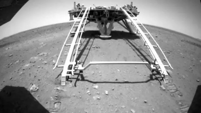 အင်္ဂါဂြိုဟ်မျက်နှာပြင်ပေါ် အခြေစိုက်တဲ့ စင်မြင့်ကနေ ဆင်းလာတဲ့ ကျူရုန့်ရဲ့ နောက်ပြန် ရိုက်လိုက်တဲ့ ဓါတ်ပုံ