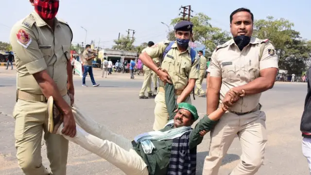 भुवनेश्वर में प्रदर्शनकारी को हटाते पुलिसकर्मी