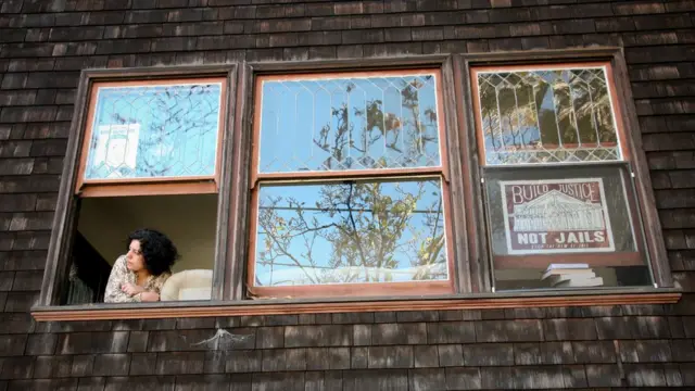 پوستری با شعار "به جای ساخت زندان، عدالت برقرار کنید" در سمت راست و طرح گرافیکی دیگری از اریک گارنر، مرد سیاه‌پوستی که با شلیک پلیس کشته شد در سمت چپ پنجره رو به کوچه خانه‌ای که صابره کاشی هم مقیم آنست توسط هم خانه‌ای‌های او که در جنبش‌های مدنی سیاه‌پوستان اوکلند فعالند نصب شده است